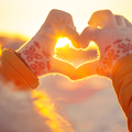 Woman hands in winter gloves Heart symbol shaped Lifestyle and Feelings concept with sunset light nature on background